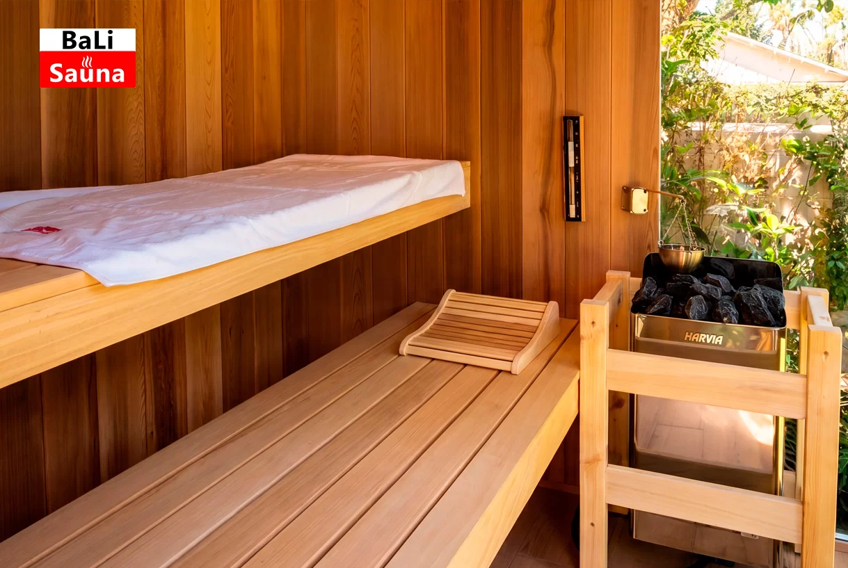 סאונת יוקרה של Bali Sauna עם חיפוי ארז קנדי אדום, זכוכית כהה ותנור Harvia