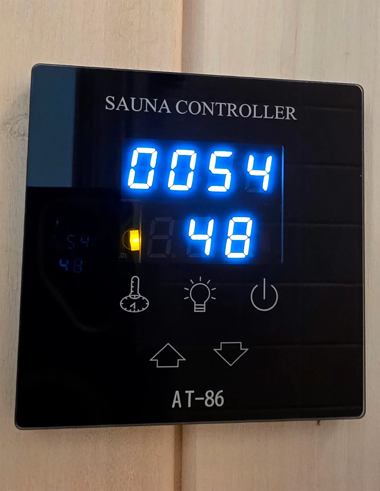 digital controller ► BaLI סאונה יוקרתית לבית ולחצר Sauna controller display showing a timer reading 00:54 and a temperature or set value of 48, with control icons below and the label SAUNA CONTROLLER at top